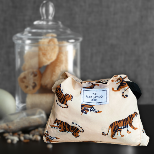 Flat lay neutral tigers drawstring make up bag lifestyle bathroom