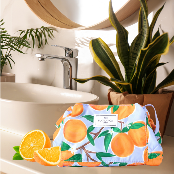 Flat Lay Co Mediterranean orange make up travel bag front profile lifestyle bathroom setting folded oranges