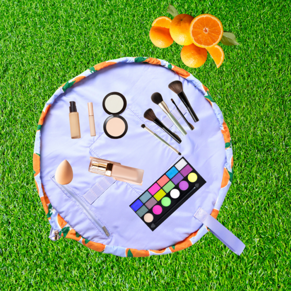 Flat Lay Co Mediterranean orange make up travel bag front profile lifestyle bathroom setting opened out flat make up on grass verge